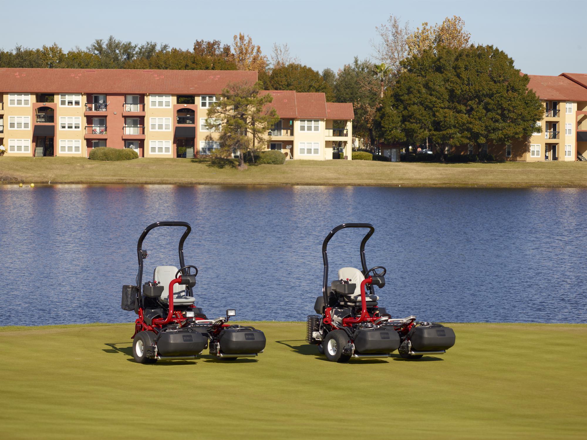 Two Toro Greensmaster TriFlex 3400's in front of a lake.