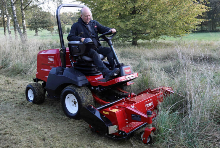 A Toro Groundsmaster 3300 cutting longer rough grass.
