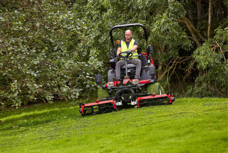 Toro LT2240 cutting rough grass on a slope.