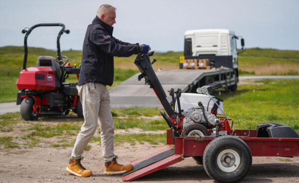 Electric Toro mower being removed from a Toro TransPro 100