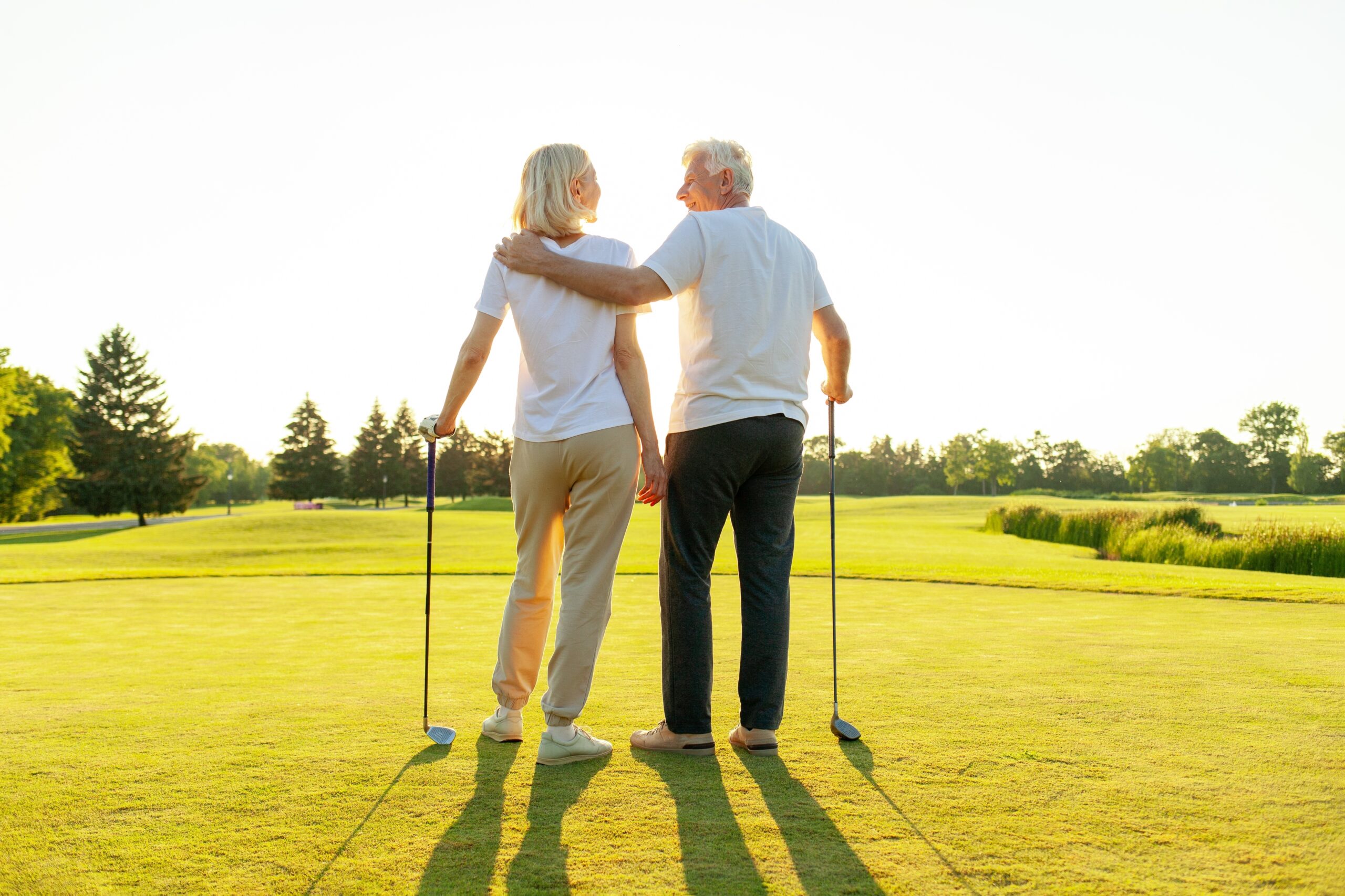 Elderly couple playing golf together